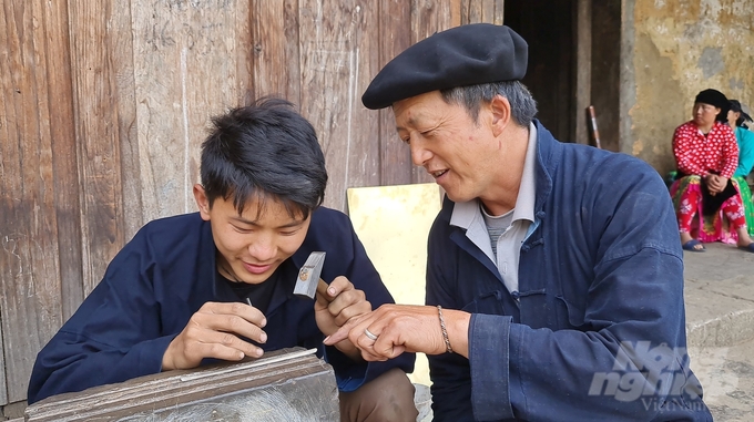 Người già của nhà họ Mua truyền nghề chạm bạc cho người trẻ. Ảnh: Đào Thanh.