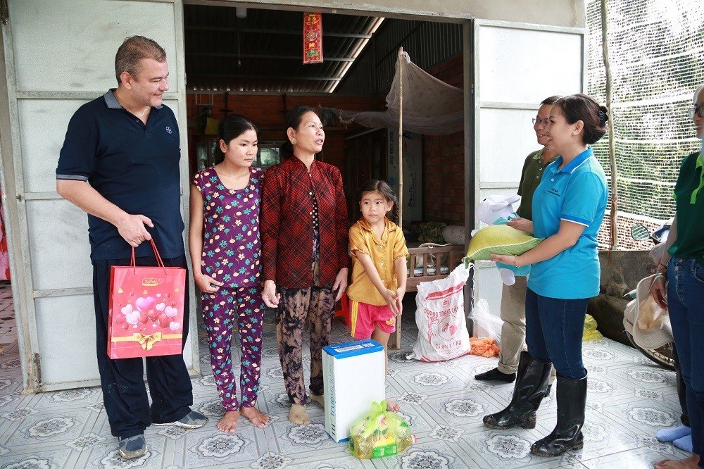 Ông Ingo Brandenburg - Tổng Giám đốc Bayer Việt Nam cùng tình nguyện viên Bayer tặng quà tại nhà hộ gia đình khó khăn.