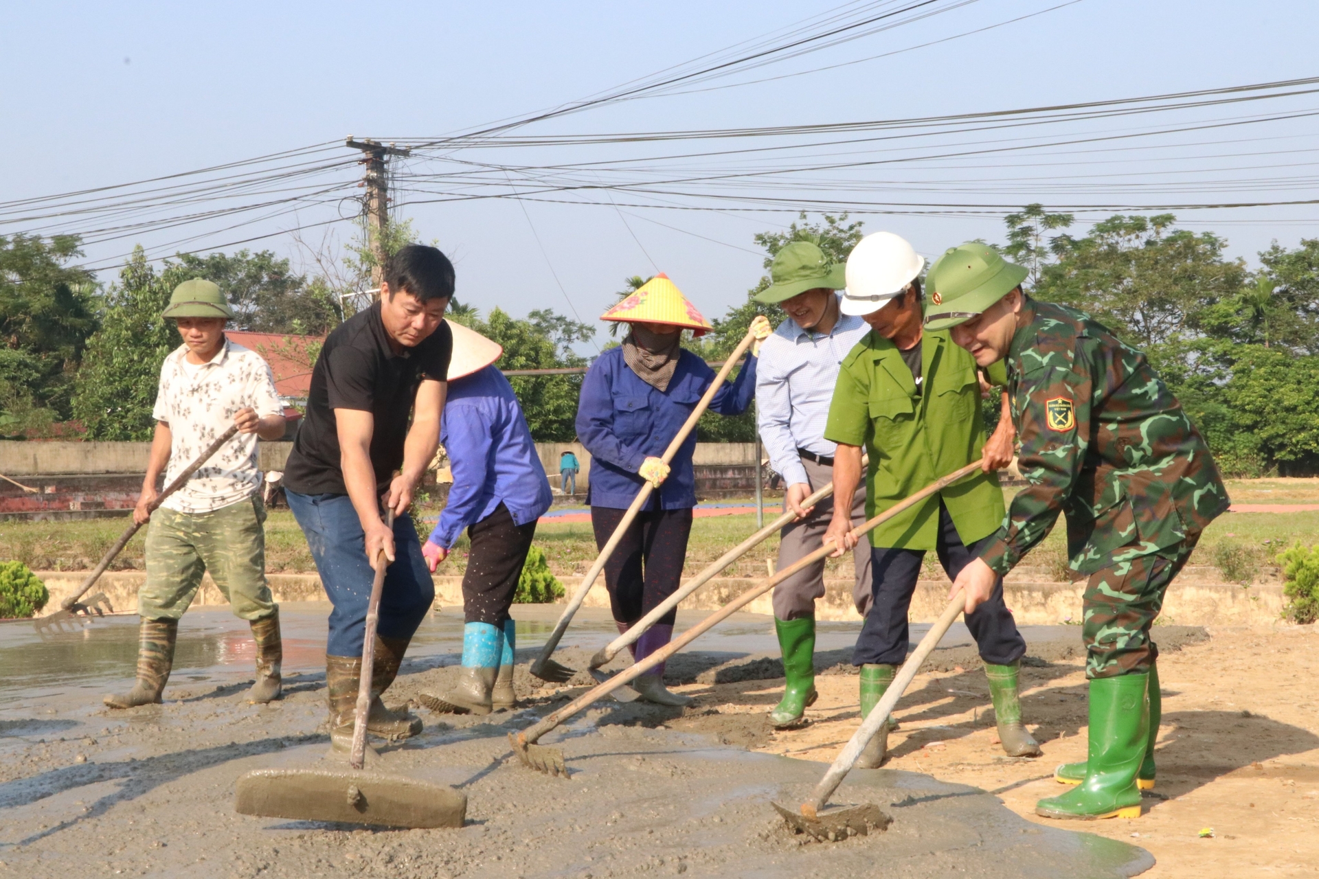 Đồng chí Trần Nhật Tân (ngoài cùng bên phải) - Bí thư Huyện ủy Trấn Yên tham gia lao động Ngày cuối tuần cùng dân làm sân chơi thể thao ở xã Y Can. Ảnh: Thanh Tiến.