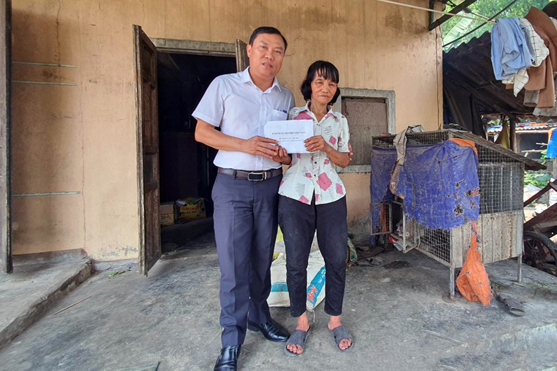 Nhà báo Phan Khiêm trao kinh phí hỗ trợ cho bà Trần Thị Hoa. Ảnh: CĐ.