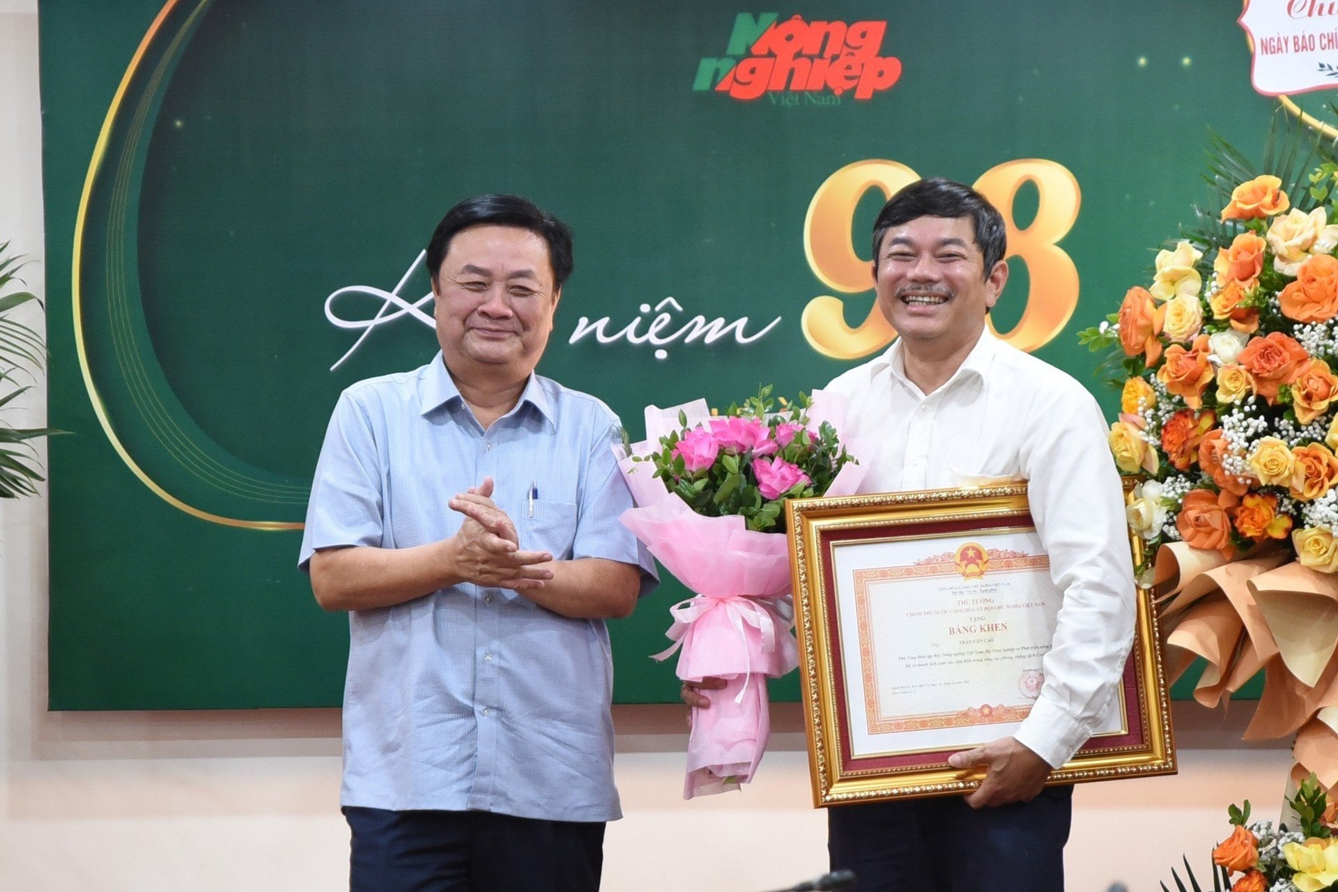 Bộ trưởng Lê Minh Hoan trao tặng Bằng khen Thủ tướng cho Phó Tổng biên tập Trần Văn Cao. Ảnh: Tùng Đinh.