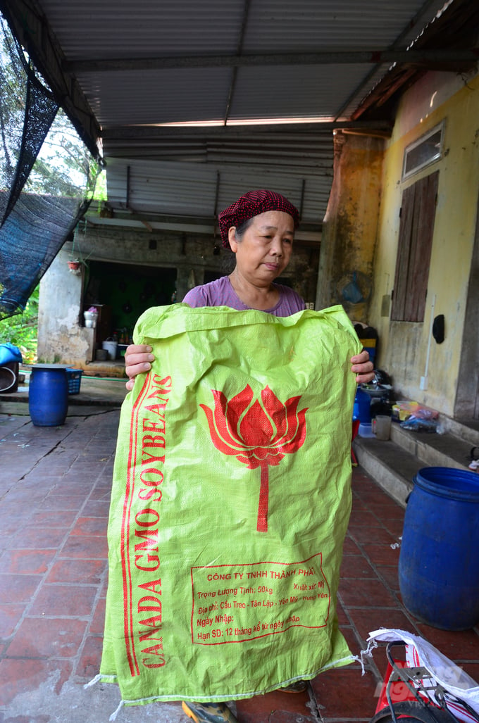 Bà Bỉnh bên bao tải đậu có in chữ GMO nhưng không ghi rõ bằng tiếng Việt là biến đổi gen, hàng của công ty Thành Phát, Hưng Yên. Ảnh: Dương Đình Tường.