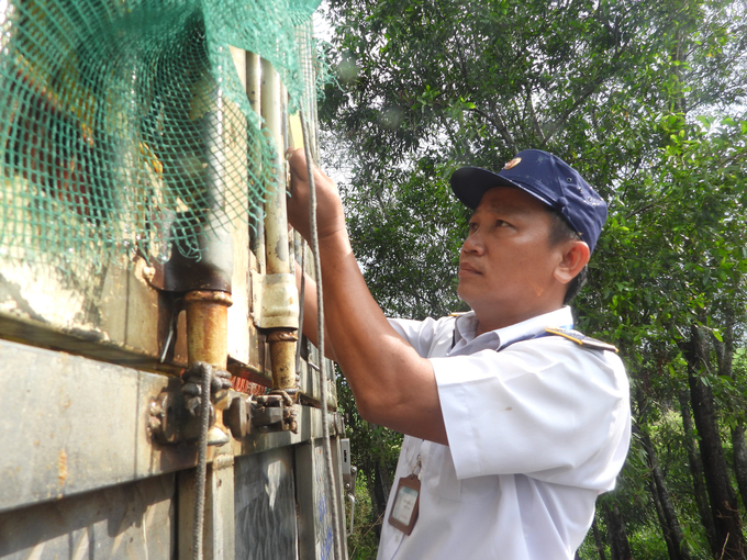 Cán bộ trạm kiểm tra niêm phong. Ảnh: Trần Trung.