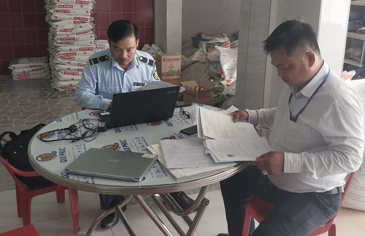 Cán bộ Đội quản lý thị trường số 4 tỉnh Tiền Giang lập biên bản cơ sở này kinh doanh thức ăn chăn nuôi vi phạm.