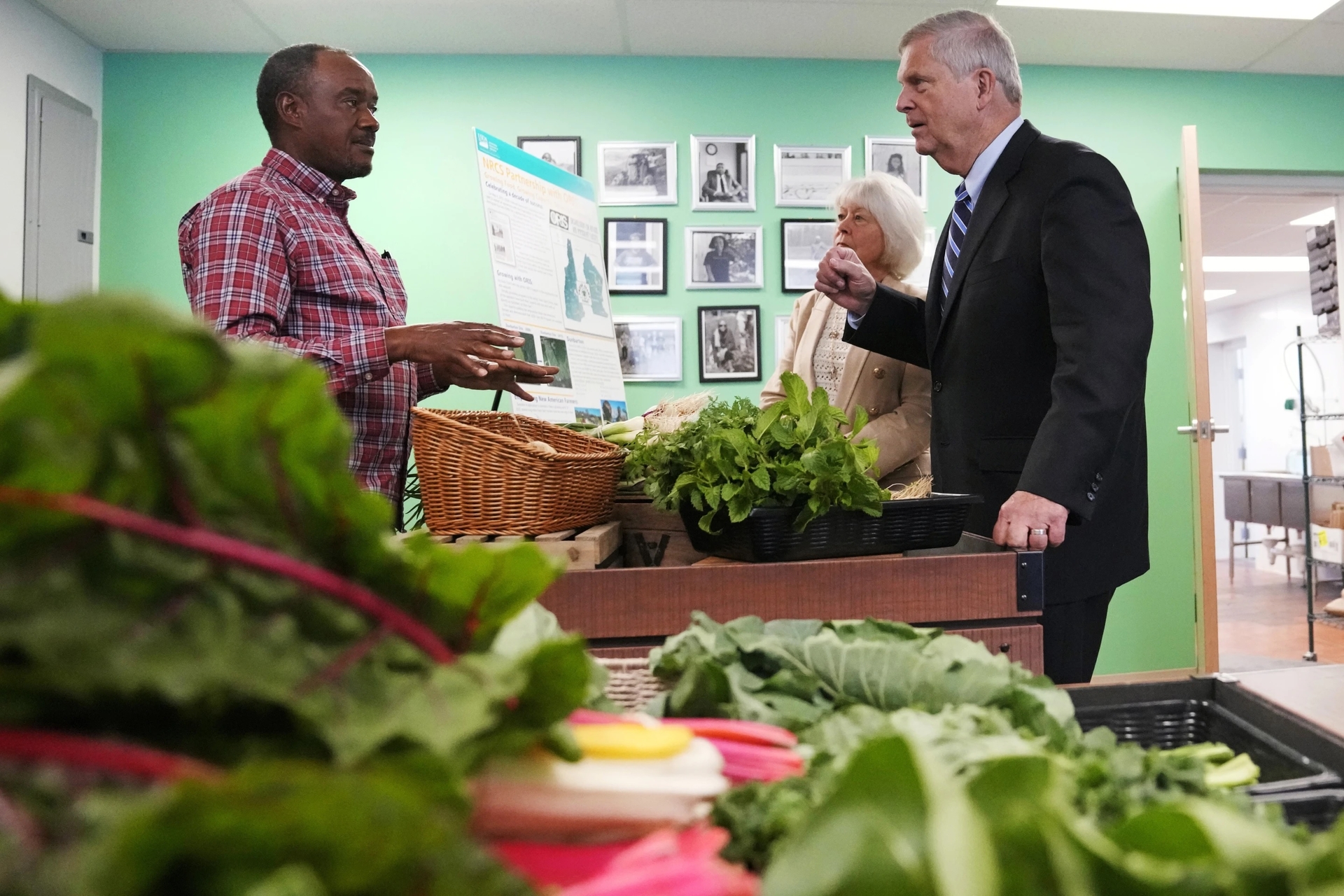 Ông Tom Vilsack, Bộ trưởng Nông nghiệp Hoa Kỳ nói chuyện với nông dân Sylvian Bukasa tại Chợ thực phẩm Fresh Start. Ảnh: AP/Charles Krupa.