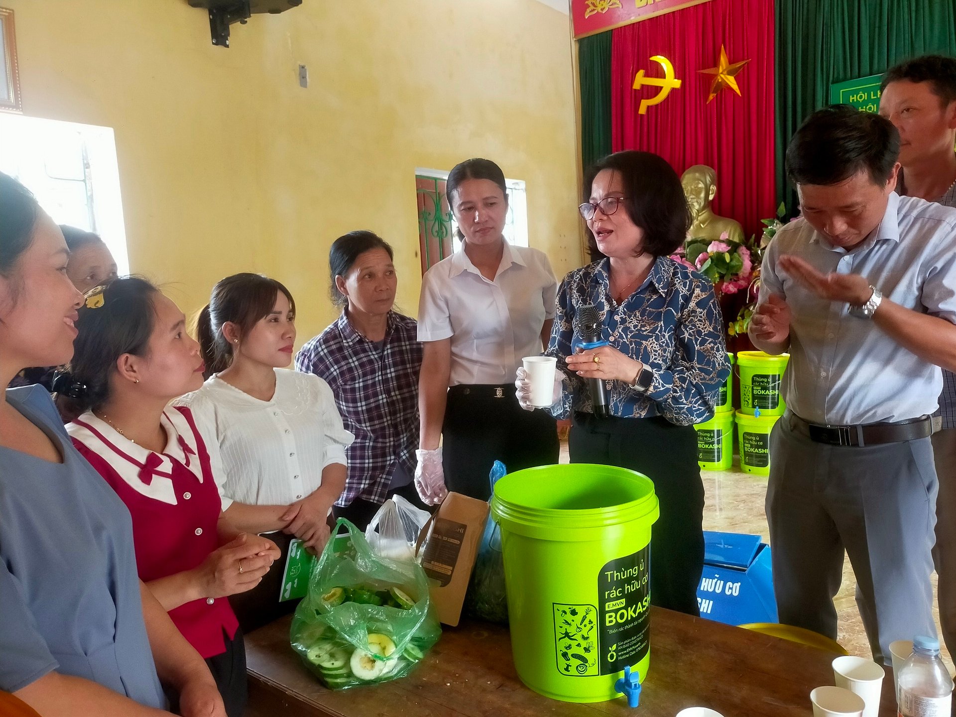 Hội Liên hiệp Phụ nữ huyện Trấn Yên hướng dẫn người dân sử dụng thùng ủ và men vi sinh để biến rác thành phân bón. Ảnh: Thanh Tiến.