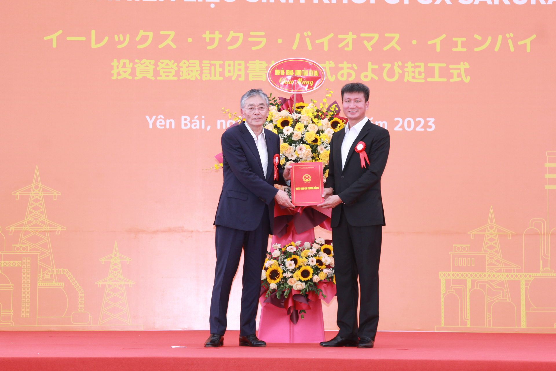Ông Trần Huy Tuấn - Chủ tịch UBND tỉnh Yên Bái trao Quyết định chấp thuận chủ trương đầu tư Dự án và tặng hoa chúc mừng Công ty Cổ phần EREX - Nhật Bản. Ảnh: Thanh Tiến.