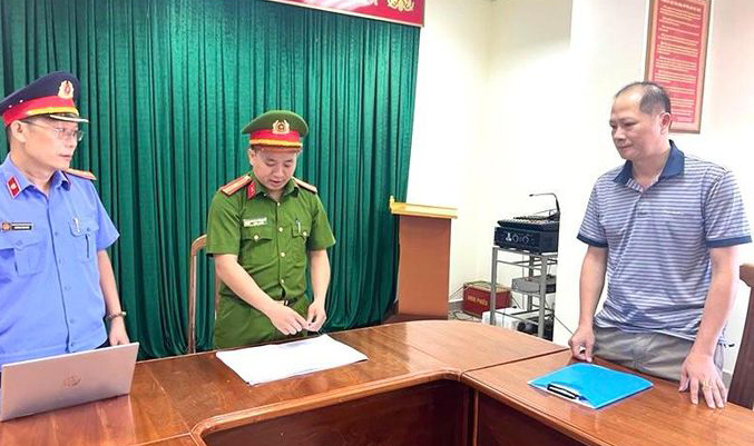 Lực lượng chức năng tống đạt quyết định khởi tố đối với bị can Nguyễn Thanh Long. Ảnh: CAQB.