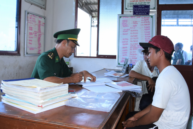 Kien Giang border guards check fishing vessel records before disembarking at the wharf from Tac Cau fishing port. Photo: Trong Linh.