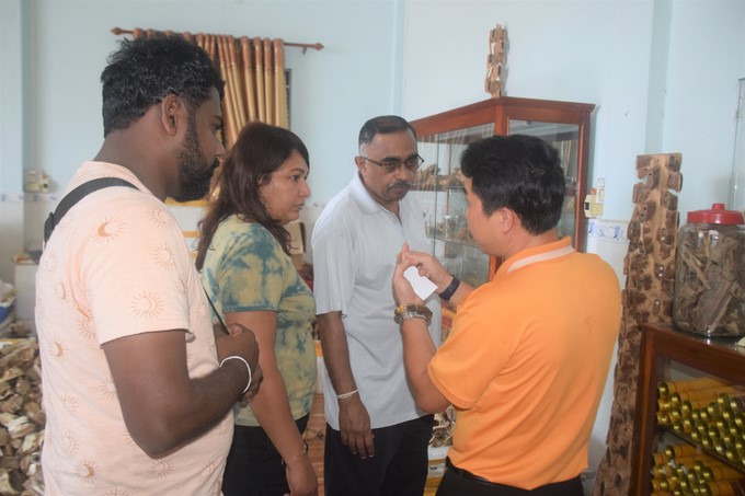Mr. Nguyen Huu Tri (yellow shirt)—Mr,Toan's son—is explaining how to make fine art products from agarwood to Sri Lankan customers. Photo: V.D.T.
