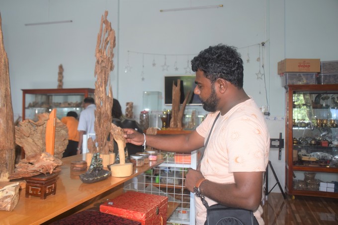 A Sri Lankan customer is admiring the fine art products made from agarwood on display at Ba Toan Agarwood Company. Photo: V.D.T.