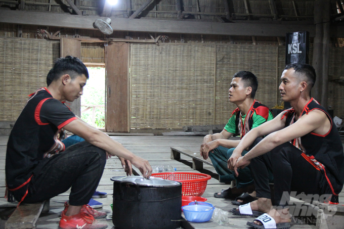 Bốn chàng trai Bahnar trò chuyện trong ngôi nhà rông của làng Kon Sơ Lăl. Ảnh: Kiên Trung.