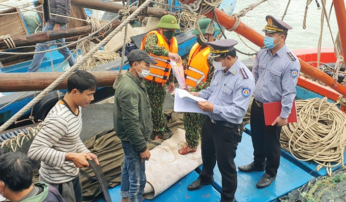 The interdisciplinary force disseminates the Law on Fisheries to fishermen on board. Photo: T.Phung.