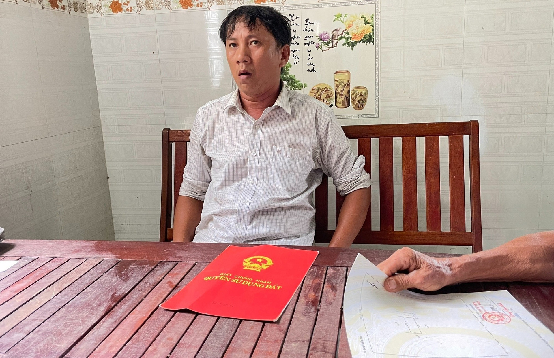 Anh Phan Thanh Tòng kể chuyện vay mượn nộp tiền làm sổ đỏ nhưng 14 năm rồi chưa được giao đất. Ảnh: V.Đ.T.