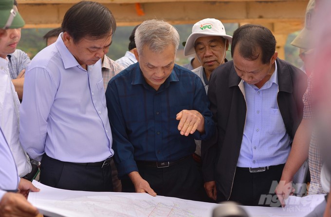 Deputy Minister of Agriculture and Rural Development Nguyen Hoang Hiep (left), experts, and authorities listen to reports on the landslide situation at the Dong Thanh reservoir structure. Photo: Minh Hau.
