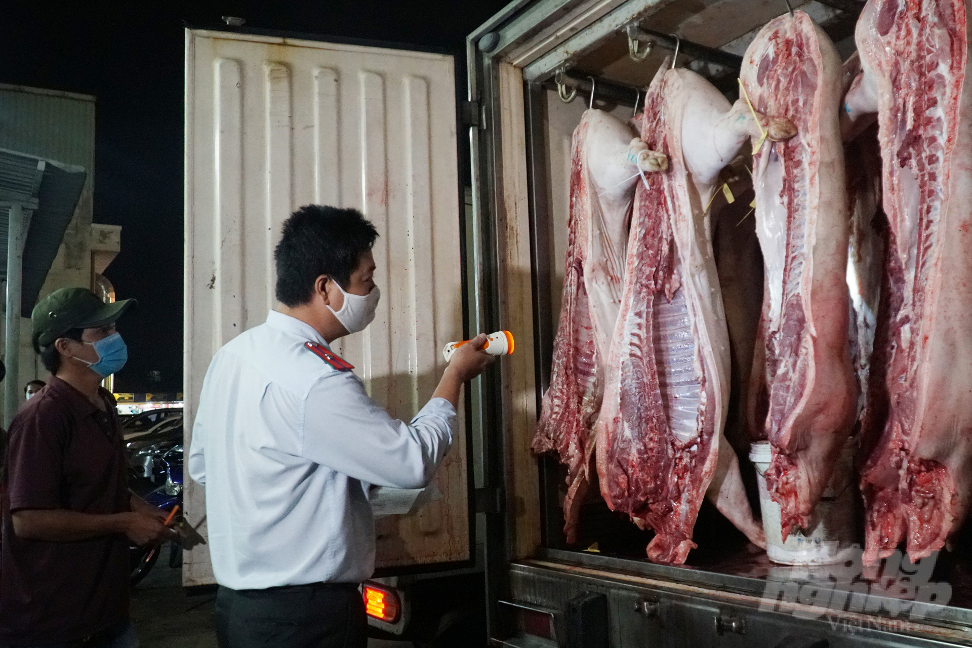 Lực lượng chức năng kiểm soát thịt heo trước khi đưa vào tiêu thụ tại chợ đầu mối Bình Điền. Ảnh: Nguyễn Thủy.