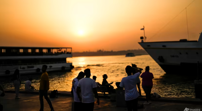 People walk along Karakoy promenade as the sun sets on a hot summer day in Istanbul, Turkey, Jul 14, 2023. Photo: AP/Francisco Seco