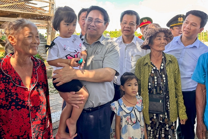 Thủ tướng thăm hỏi người dân khu vực dân cư vành đai nam Đông Hồ (TP. Hà Tiên, tỉnh Kiên Giang) trong chuyến khảo sát kè chống sạt lở. Ảnh: VGP.