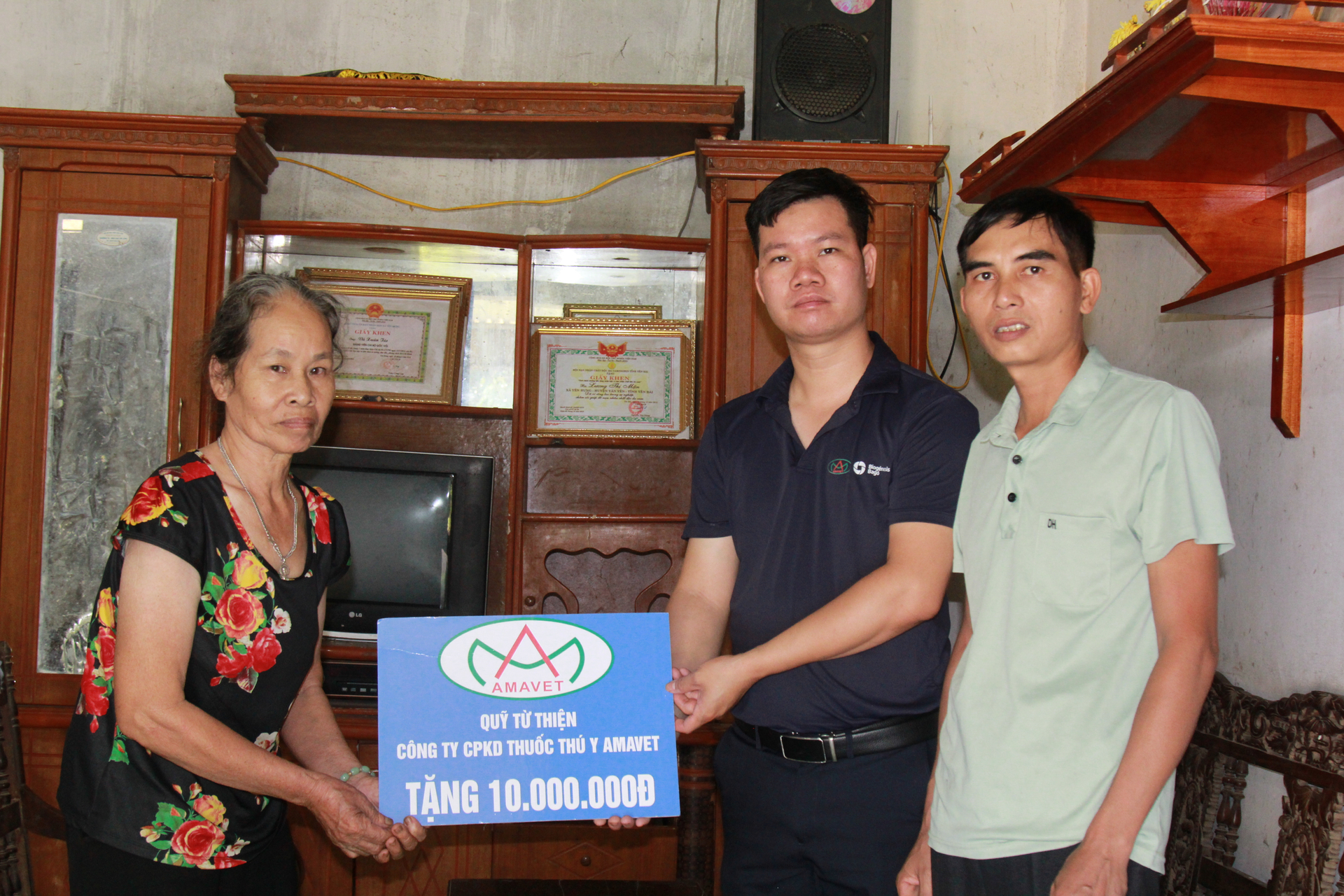 Đại diện Công ty cổ phần Kinh doanh thuốc thú y Amavet trao hỗ trợ cho gia đình bà Lương Thị Mận. Ảnh: Thanh Tiến.