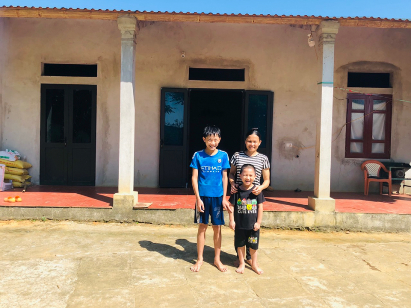 Gia đình em Thuận trước căn nhà mới được cộng đồng chung tay giúp đỡ xây dựng lại. Ảnh: Quốc Toản.
