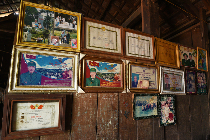 The stilt house's wall is hung with certificates of merit and commemorative photos of Ma Nha (Y Chuon). Photo: Tung Dinh.