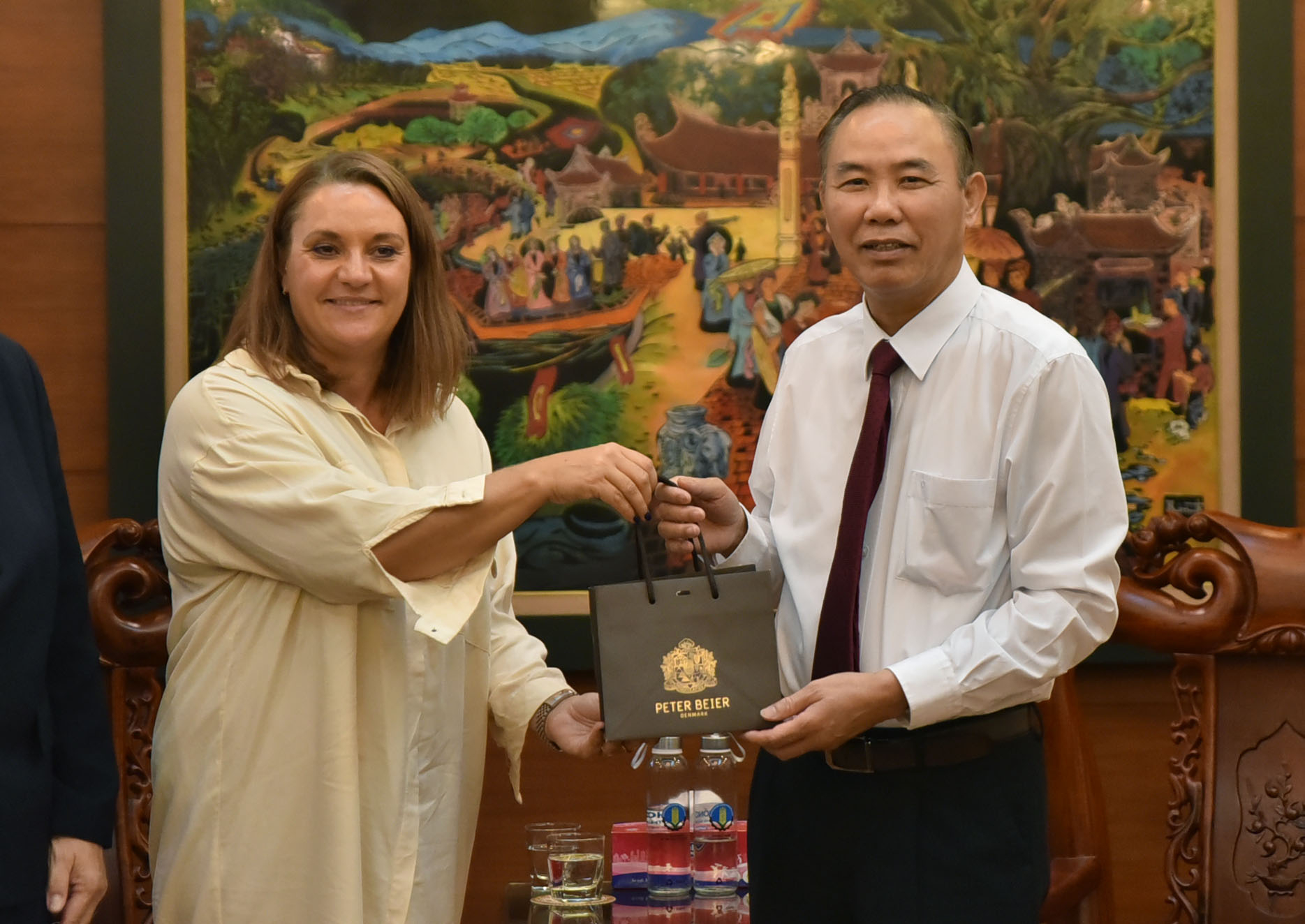 Ms. Mette Ekeroth, Deputy Head of Mission of the Royal Danish Embassy to Vietnam presents a gift to Deputy Minister Phung Duc Tien.