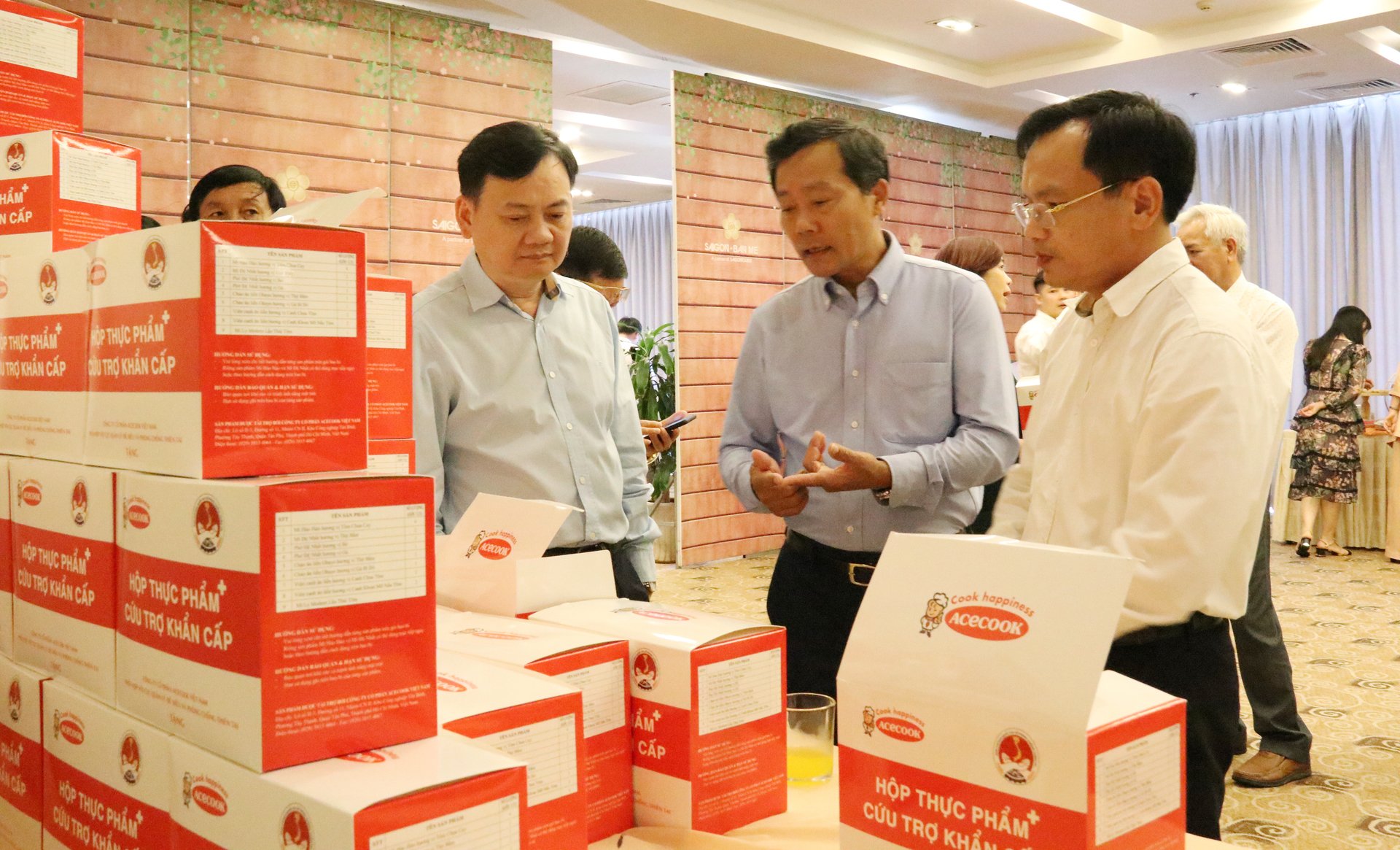 Các đại biểu tìm hiểu hộp thực phẩm cứu trợ khẩn cấp của Công ty Acecook. Ảnh: Quang Yên.