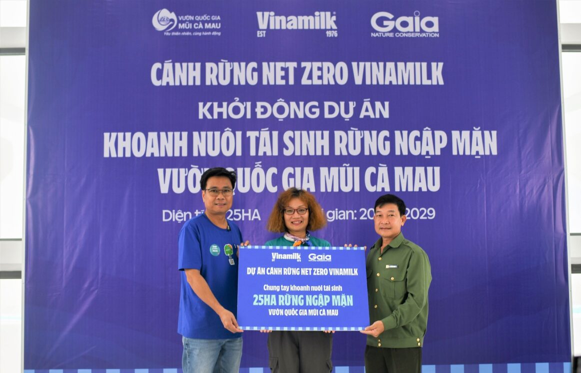 Ông Lê Hoàng Minh (bên trái) đại diện Vinamilk và bà Đỗ Thị Thanh Huyền đại diện Gaia trao tượng trưng bảng 25ha rừng ngập mặn thuộc dự án 'Cánh rừng Net Zero Vinamilk' cho đại diện Vườn Quốc gia Mũi Cà Mau.