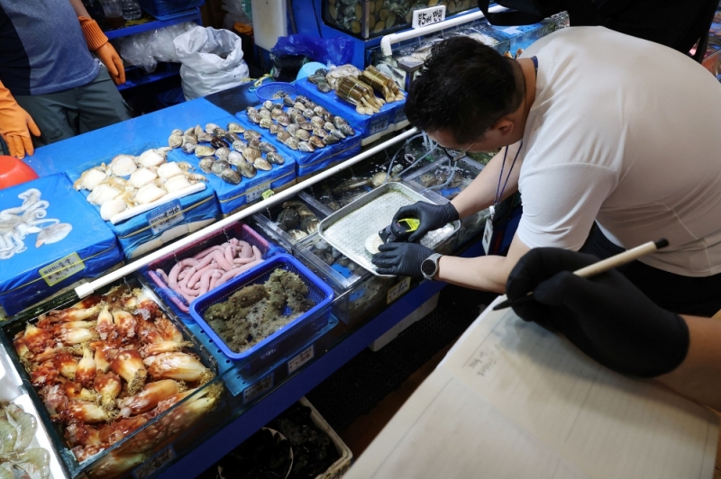 So điệp nhập khẩu từ Nhật Bản được đo nồng độ phóng xạ tại chợ hải sản Noryangjin ở Seoul, Hàn Quốc hồi tháng 7/2023. Ảnh: Reuters.