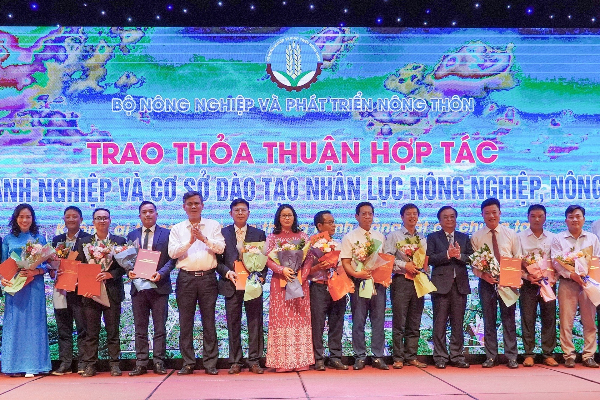 Bộ trưởng Bộ NN-PTNT Lê Minh Hoan và Chủ tịch UBND tỉnh Quảng Bình Trần Thắng tặng hoa chúc mừng thỏa thuận hợp tác giữa doanh nghiệp và cơ sở đào tạo nhân lực nông nghiệp, nông thôn. Ảnh: Ngọc Hải.