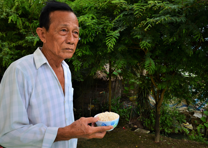 Ông Nguyễn Văn Bạc - một diêm dân ở xã Vĩnh Thịnh bên bát muối hồng. Ảnh: Dương Đình Tường.