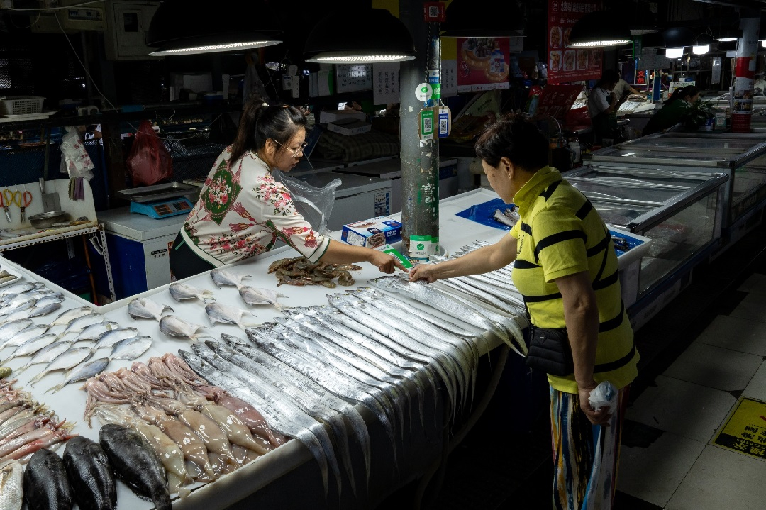 Một khách hàng đang chọn cá tại chợ hải sản ở Bắc Kinh, Trung Quốc. Ảnh: Bloomberg.