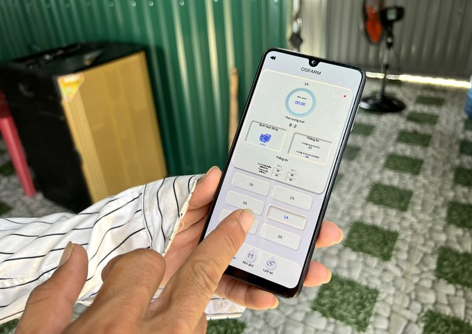 Mr. Dinh Cong Quang performs operations on the app to control watering on the farm. Photo: Thanh Son.