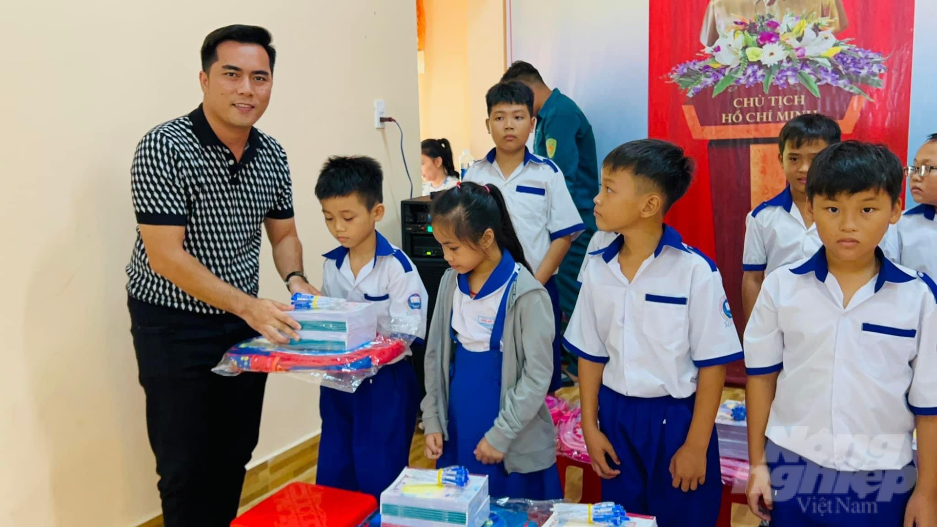 Ông Nguyễn Chí Thiện, đại diện Công ty Mỹ phẩm Đông Anh trao dụng cụ học tập cho các em học sinh. Ảnh: Trọng Linh.