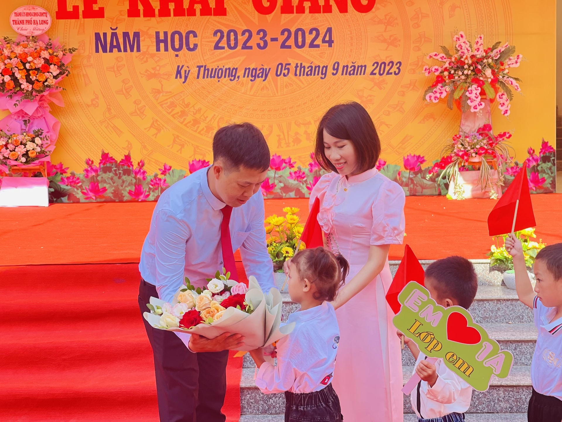 Thầy giáo Nguyễn Đức Hùng, Hiệu trưởng trường TH&THCS Kỳ Thượng, tặng hoa cho các em học sinh trong ngày khai giảng. Ảnh: Nguyễn Thành.