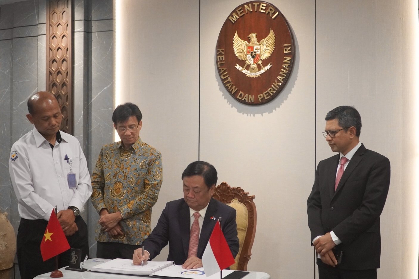 Minister Le Minh Hoan signed a guestbook while visiting the Indonesian Ministry of Marine Affairs and Fisheries.