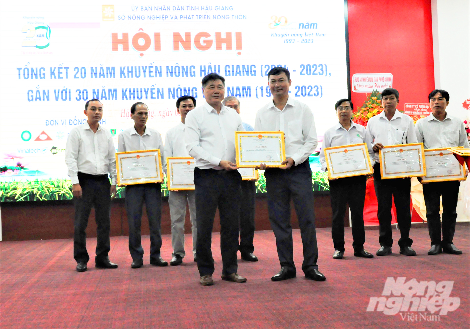 Mr. Le Quoc Thanh presenting certificates of merit to exemplary individuals who contributed to the development of agricultural extension activities in Hau Giang province. Photo: Trung Chanh.