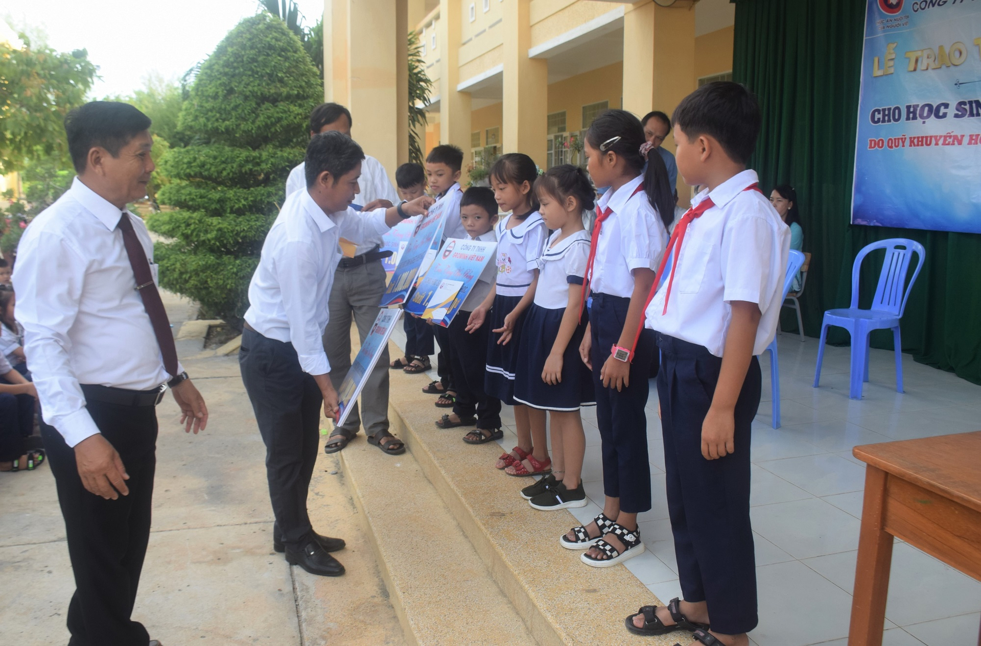 Ông Huỳnh Văn Thăng, Phó trưởng khu vực Phú Yên của Công ty TNHH GroMinh Việt Nam, trao học bổng cho các cháu Trường Tiểu học số 2 An Ninh Đông. Ảnh: V.Đ.T.