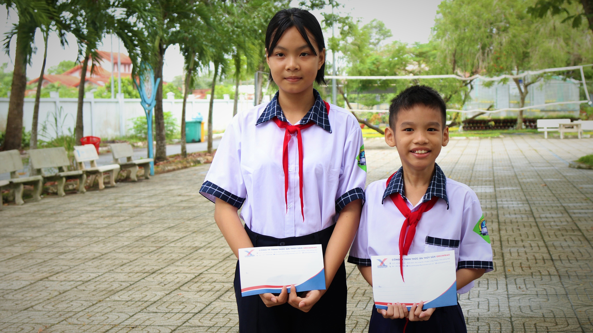 Em Lê Thảo Nguyên (trái) và em Ngô Hoàng Quân (phải) vui mừng khi được nhận suất học bổng từ Quỹ khuyến học GrowMax. Ảnh: Trần Phi.