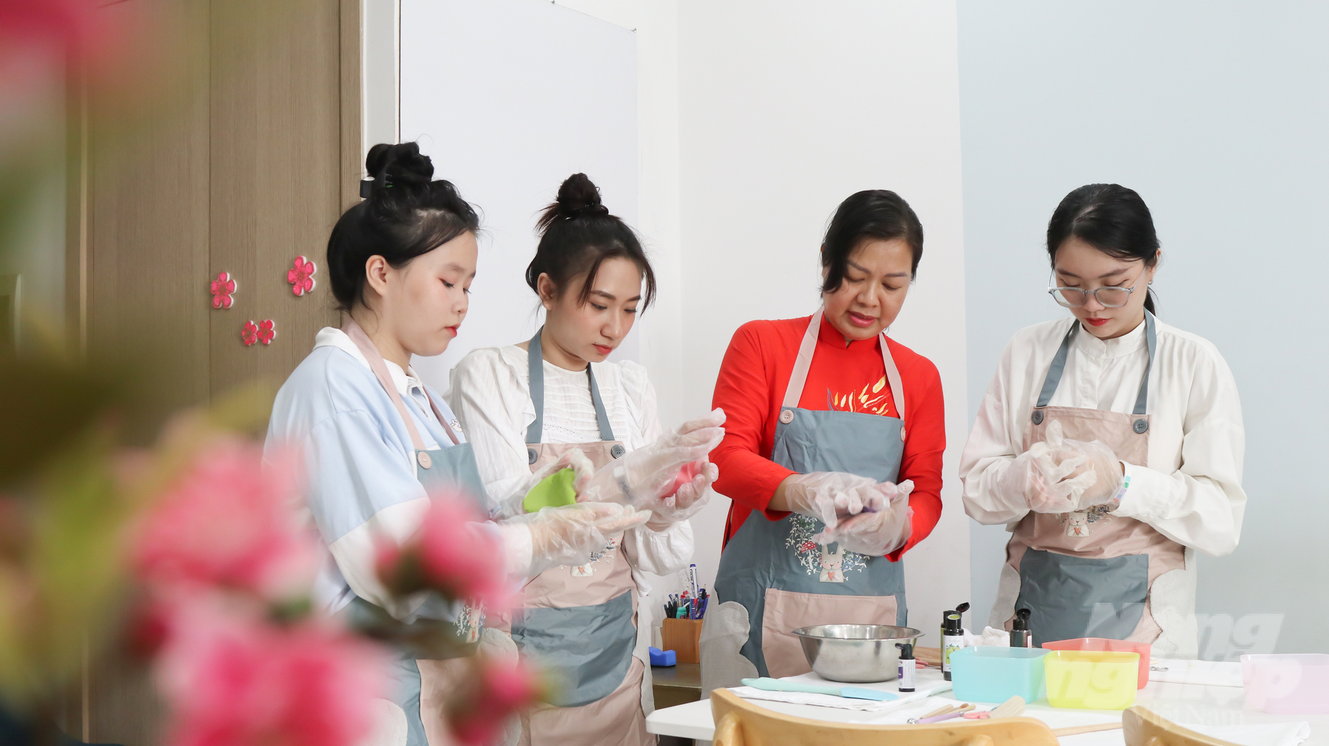 Chị Linh Vy đang dạy học trò nhào bột làm bánh.