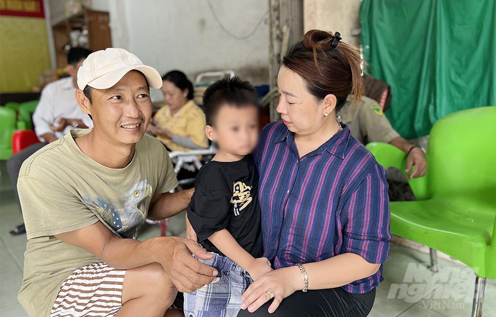 Anh Bùi Hữu Thành (con trai ông Thọ) cùng người dân chăm sóc bé K. Ảnh: Tiến Tầm. 