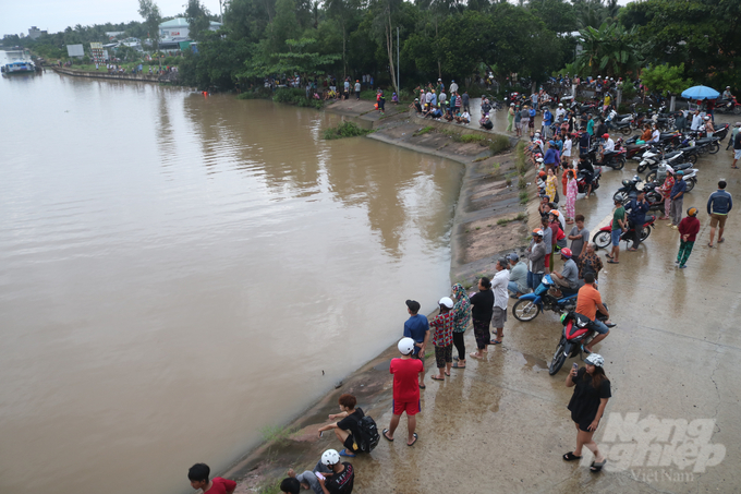 Rất đông người dân đến theo dõi lực lượng cứu hộ tìm kiếm hai học sinh bị nước cuốn mất tích tại cống Láng Thé. Ảnh: CTV.