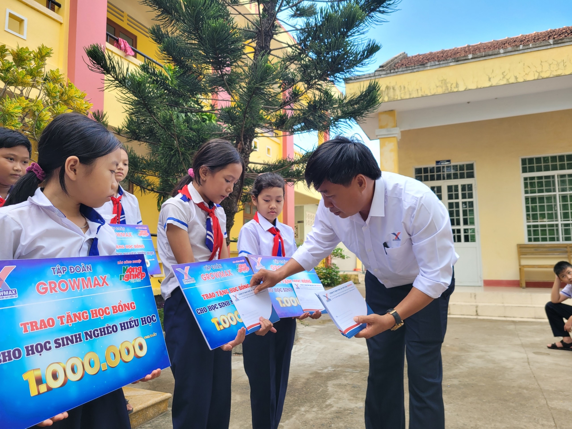 Ông Nguyễn Văn Đại, Giám đốc Khu vực miền Trung 2 (Công ty TNHH Thức ăn Thủy sản GrowMax) trao những suất học bổng cho các em học sinh. Ảnh: PC.