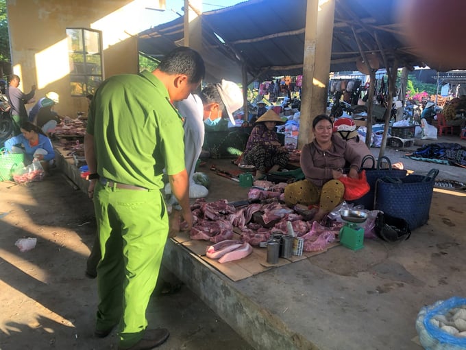Tổ công tác cấp phường, xã ở thị xã An Nhơn kiểm tra thịt heo bán tại các chợ. Ảnh: V.Đ.T.