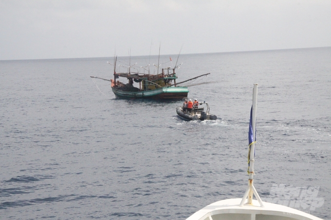 The working group's canoe approaches the fishing vessel in the sea. Photo: Kien Trung.