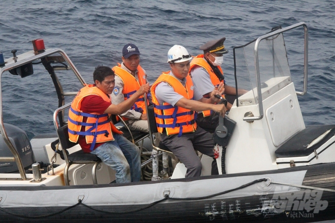 The patrol team took pilot Ho Van Buon to ship KN-506 to check fishing logs at sea. Photo: Kien Trung.
