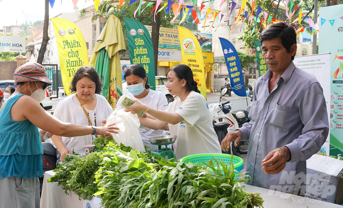 Mayu Ino (thứ 2 từ trái sang) hỗ trợ bà con nông dân tỉnh Đồng Tháp đưa rau hữu cơ bán tại Phiên chợ Xanh - Tử tế vào mỗi cuối tuần. Ảnh: Nguyễn Thủy.