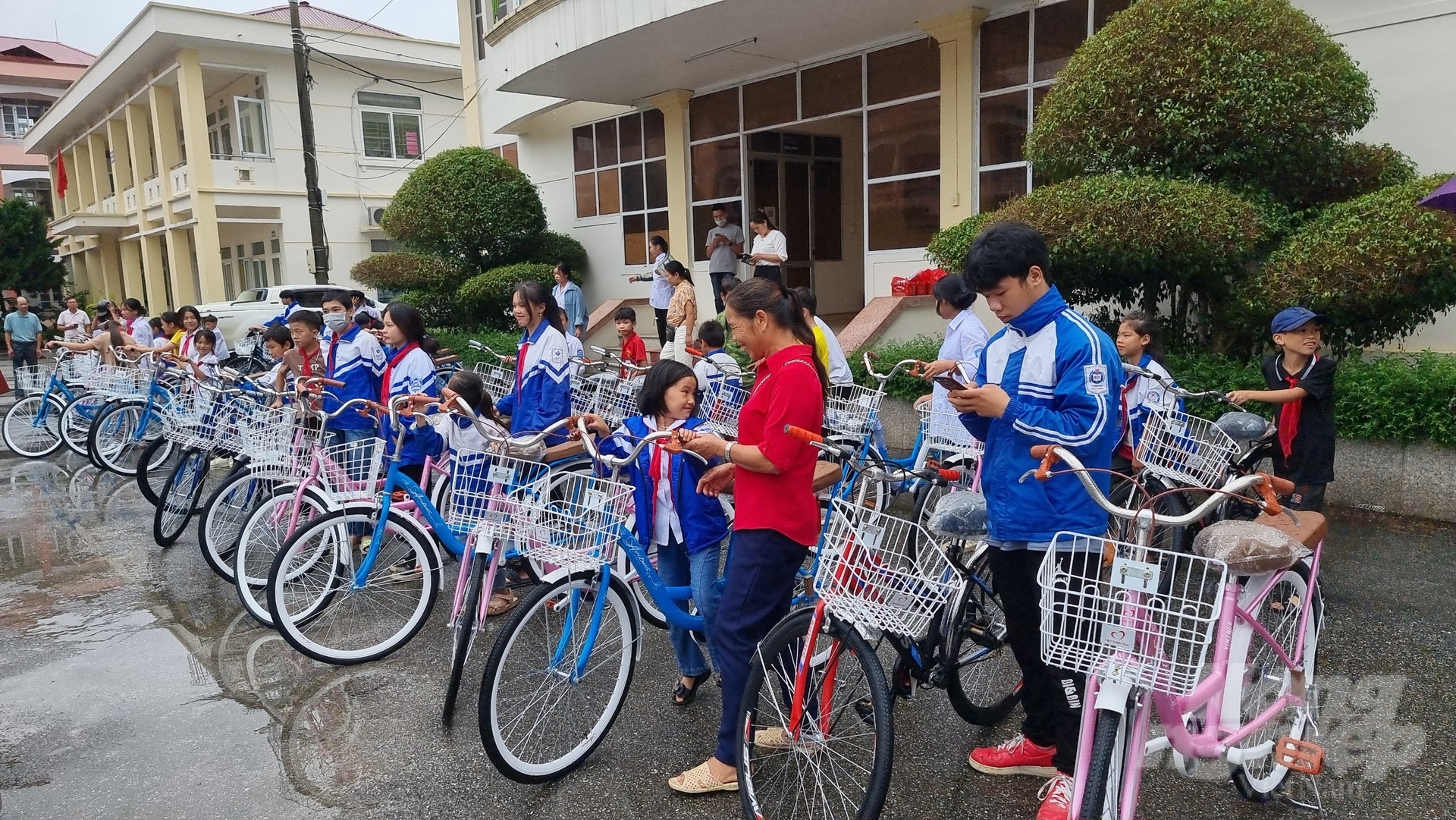 Các học sinh và phụ huynh vui vẻ khi nhận được xe đạp. Ảnh: Toán Nguyễn.