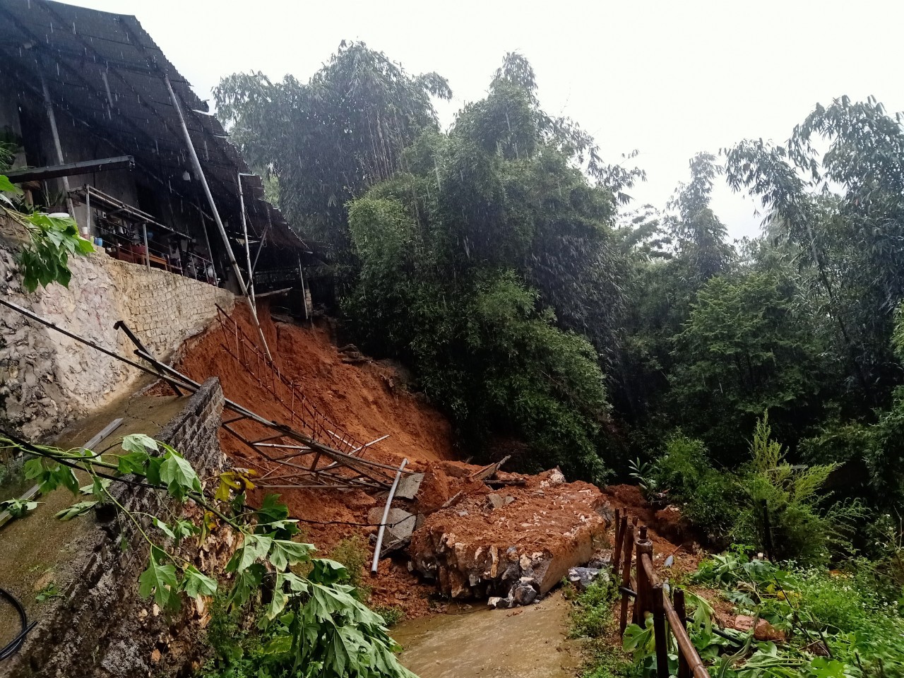 Các tuyến liên xã, liên thôn ở Sa Pa cũng bị mưa lớn gây sạt lở đất đá. Trên ảnh là nhà một hộ dân bị sạt lở ở phường Cầu Mây (Sa Pa). Nền nóng nhà lăn xuống đường, các phương tiện, người dân không thể qua lại. 