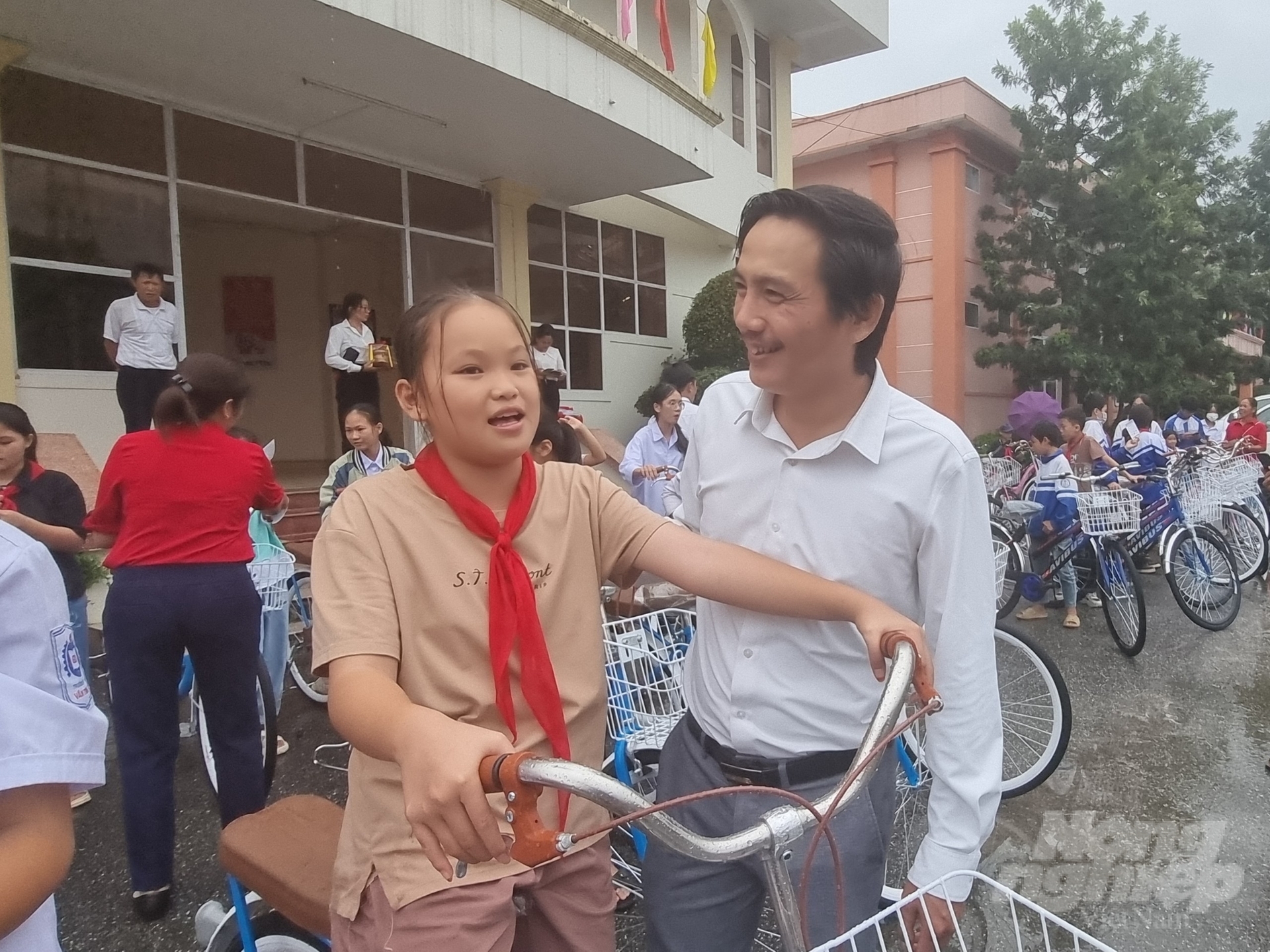 Ông Vũ Minh Việt nói chuyện cùng 1 cháu học sinh nghèo được nhận xe đạp. Ảnh: Toán Nguyễn.